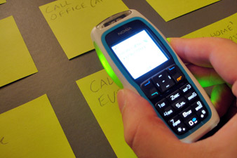 The phone resting on a post-it on the desk surface, showing a confirmation prompt
