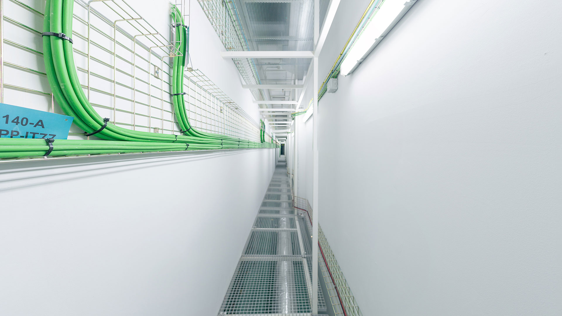 Inside a data centre: rows of server racks with orange and blue cabling visible between units