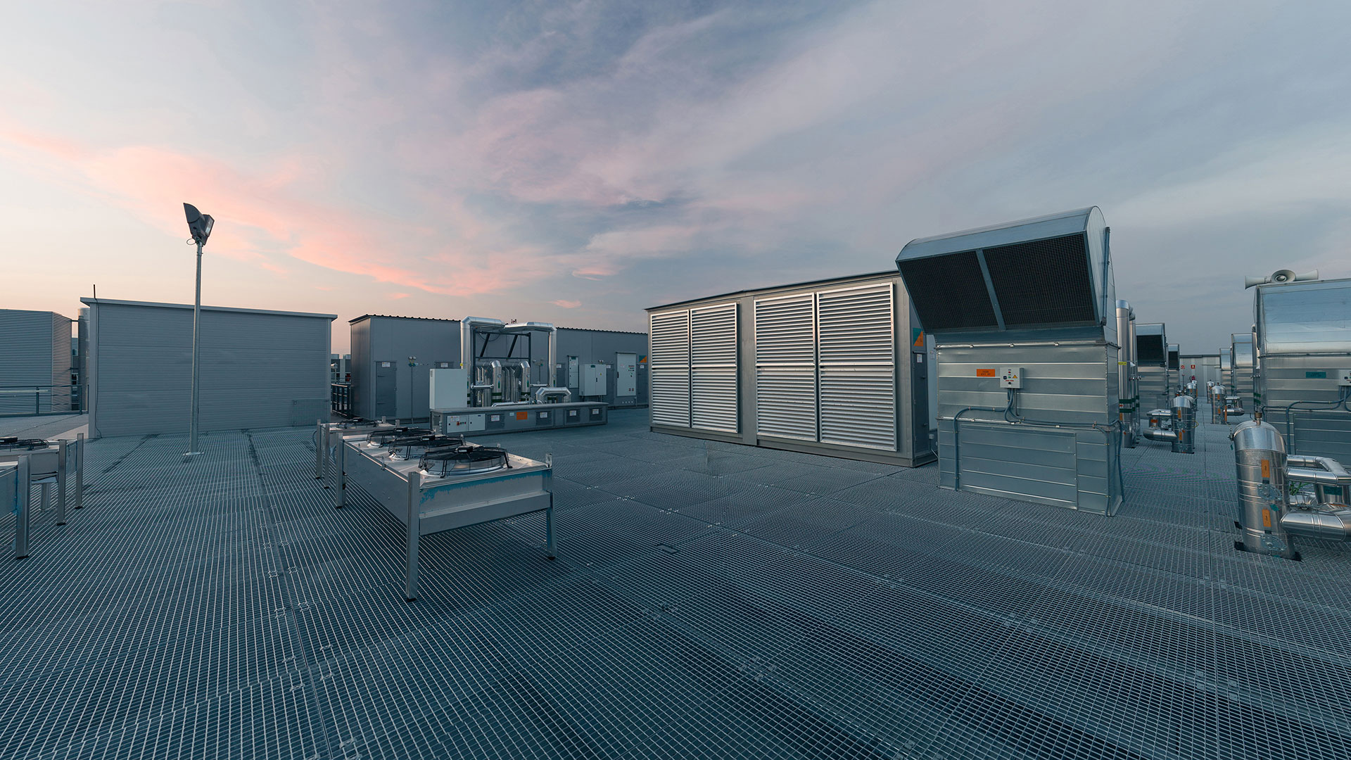 Low-angle view along a data centre aisle, floor vents in the foreground and server racks receding into the background
